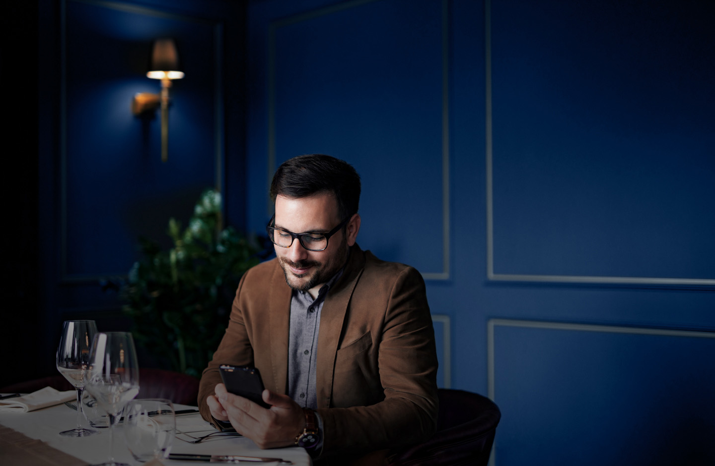 Junger Mann sitzt an seinem Laptop und arbeitet